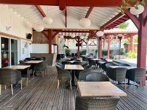 a restaurant with wooden tables and chairs and tables at Camping Pays Basque in Bidart