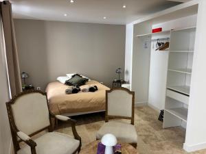 a bedroom with a bed with two chairs and a table at Chaleureux T1 avec Balcon in Vals-les-Bains