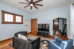 a living room with a blue couch and a tv at Historical John H Dickman House in Covington