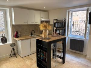 a kitchen with a island with a vase on it at Chaleureux T1 avec Balcon in Vals-les-Bains