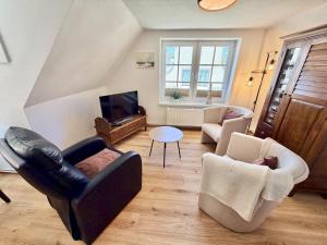 a living room with two chairs and a television at Ferienhaus Maria in Warnemünde