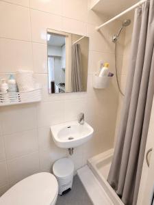 a bathroom with a toilet and a sink and a shower at Central Lisbon Apartment Santos Walk to Cais do Sodré in Lisbon +9 photos