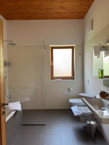 a bathroom with two toilets and a sink and a window at Garnì Tuttotondo in Levico Terme