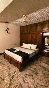 a bedroom with a large bed with a wooden headboard at THANAL homes in Kollam