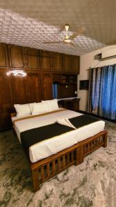 a bedroom with a large bed with wooden cabinets at THANAL homes in Kollam