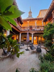 a courtyard of a building with chairs and tables at Casón del Conde in Orgaz