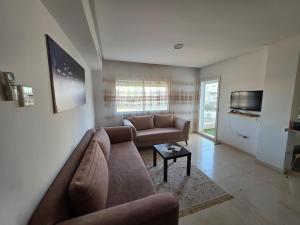 a living room with a couch and a tv at luxurious two bedroom appartement in Hiboun