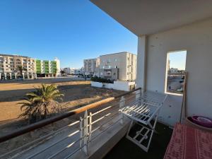 a white chair sitting on a balcony with a window at luxurious two bedroom appartement in Hiboun