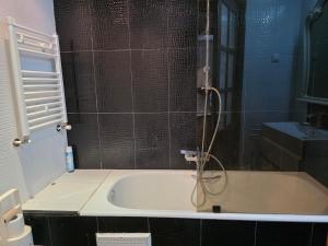 a bathroom with a bath tub with a shower at luxurious two bedroom appartement in Hiboun +18 photos