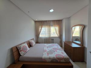 a bedroom with a bed with a dresser and a mirror at luxurious two bedroom appartement in Hiboun