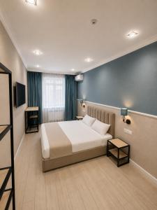 a hotel room with a bed and a television at Aqua Hotel in Bishkek