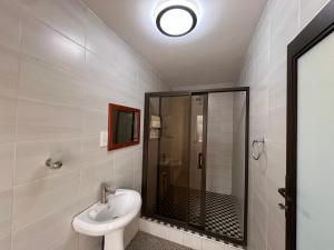 a bathroom with a shower and a toilet and a sink at Nduna Legacy Lodge in Harare