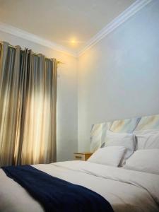 a bedroom with a large bed and a window at Nehema Appartments in Lubumbashi