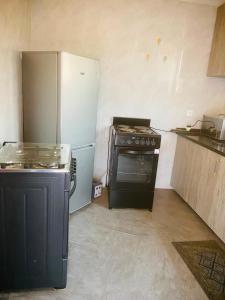 a kitchen with a stove and a refrigerator at Nehema Appartments in Lubumbashi