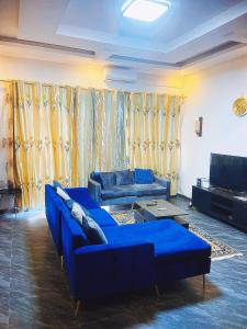 a living room with blue couches and a couch at Nehema Appartments in Lubumbashi