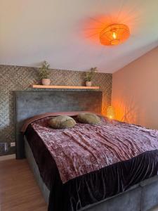 a bedroom with a bed with two pillows on it at Parc La Dune Dutch Lodge in Warmenhuizen