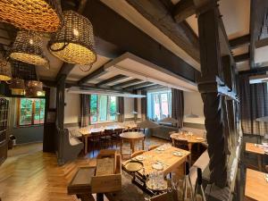 a restaurant with wooden tables and chairs and windows at Hôtel de l'Ange in Niedermorschwihr