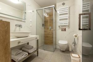 a white bathroom with a sink and a shower at Centralis Hotel in Haskovo