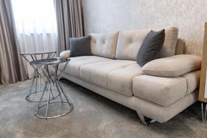a couch with two pillows on it in a living room at Centralis Hotel in Haskovo +148 photos