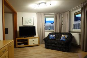 a living room with a chair and a flat screen tv at Ferienwohnung Fam. Höhn in Kappel-Grafenhausen