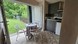 a small kitchen with a table and chairs and a window at Studio Eli sa dvorištem in Veliko Gradište +6 photos