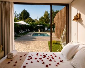 a bedroom with roses on a bed with a view of a pool at Villã - Casas de Campo in Paredes +30 photos
