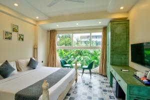 a bedroom with a bed and a large window at The Goa Courtyard by Forever stays in Arpora