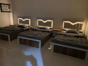 three beds in a room with lights on them at كازا in Taif