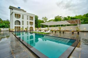 a swimming pool in front of a building at The Goa Courtyard by Forever stays in Arpora
