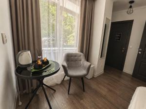 a room with a chair and a table and a window at Silver Residence Brașov in Braşov
