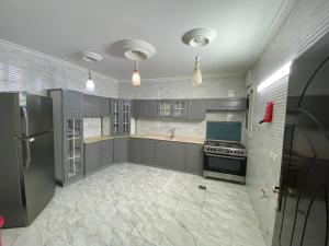 a large kitchen with gray cabinets and a refrigerator at كازا in Taif