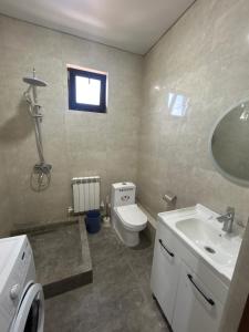 a bathroom with a white toilet and a sink at МилаДэя in Kapchagay