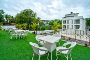 a row of tables and chairs on a lawn at The Goa Courtyard by Forever stays in Arpora