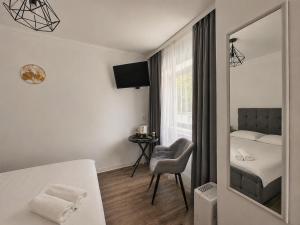a bedroom with a bed and a chair and a mirror at Silver Residence Brașov in Braşov