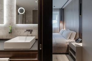ein Badezimmer mit Waschbecken und Bett in der Unterkunft Emery Hotel in Pristina + 62 Fotos