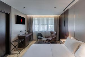 ein Hotelzimmer mit Bett, Schreibtisch und Stuhl in der Unterkunft Emery Hotel in Pristina