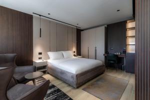 ein Schlafzimmer mit einem Bett, einer Couch und einem Stuhl in der Unterkunft Emery Hotel in Pristina