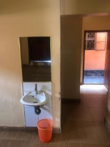 a bathroom with a sink and a tv on the wall at KBK COMFORT Accommodation in Kampala