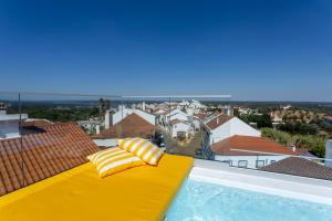 a yellow bench on the edge of a swimming pool at DamnView Montargil Alentejo in Montargil