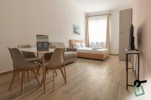 a living room with a table and chairs and a couch at Collegno Cozy Apartments in Turin