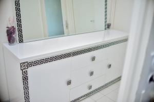 a bathroom with a white dresser with a mirror at super apparemment pour vos vacances in Neuilly-sur-Marne +8 photos