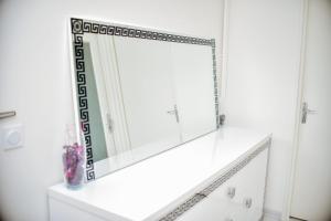 a mirror on a white wall in a bathroom at super apparemment pour vos vacances in Neuilly-sur-Marne