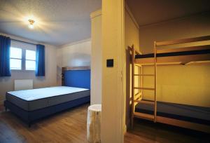 a room with a bed and bunk beds in it at Moontain Lodge in Oz
