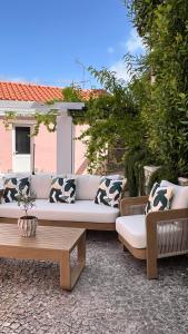 a couch and a coffee table on a patio at Chalet do Eléctrico 92' in Sintra +39 photos