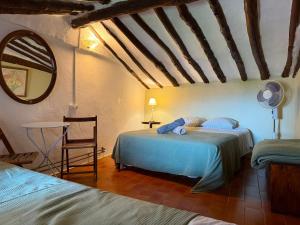 a bedroom with two beds and a chair and a mirror at Albergue OasisTrails for pilgrims on Camino de Santiago in Villamayor de Monjardín