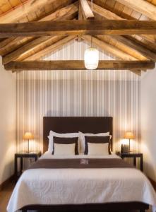 a bedroom with a large bed with wooden ceilings at Casón del Conde in Orgaz +19 photos