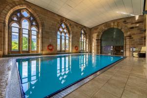 a large swimming pool in a building with windows at Moat House 8 Harris Apartment in Fort Augustus