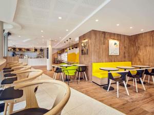 a restaurant with tables and chairs in a cafeteria at Mercure Paris la Défense Grande Arche in Nanterre