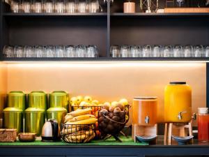 a shelf with a basket of fruit and a jug of orange juice at Mercure Paris la Défense Grande Arche in Nanterre