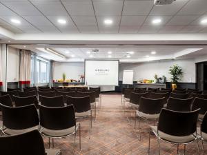 a conference room with chairs and a white screen at Mercure Paris la Défense Grande Arche in Nanterre